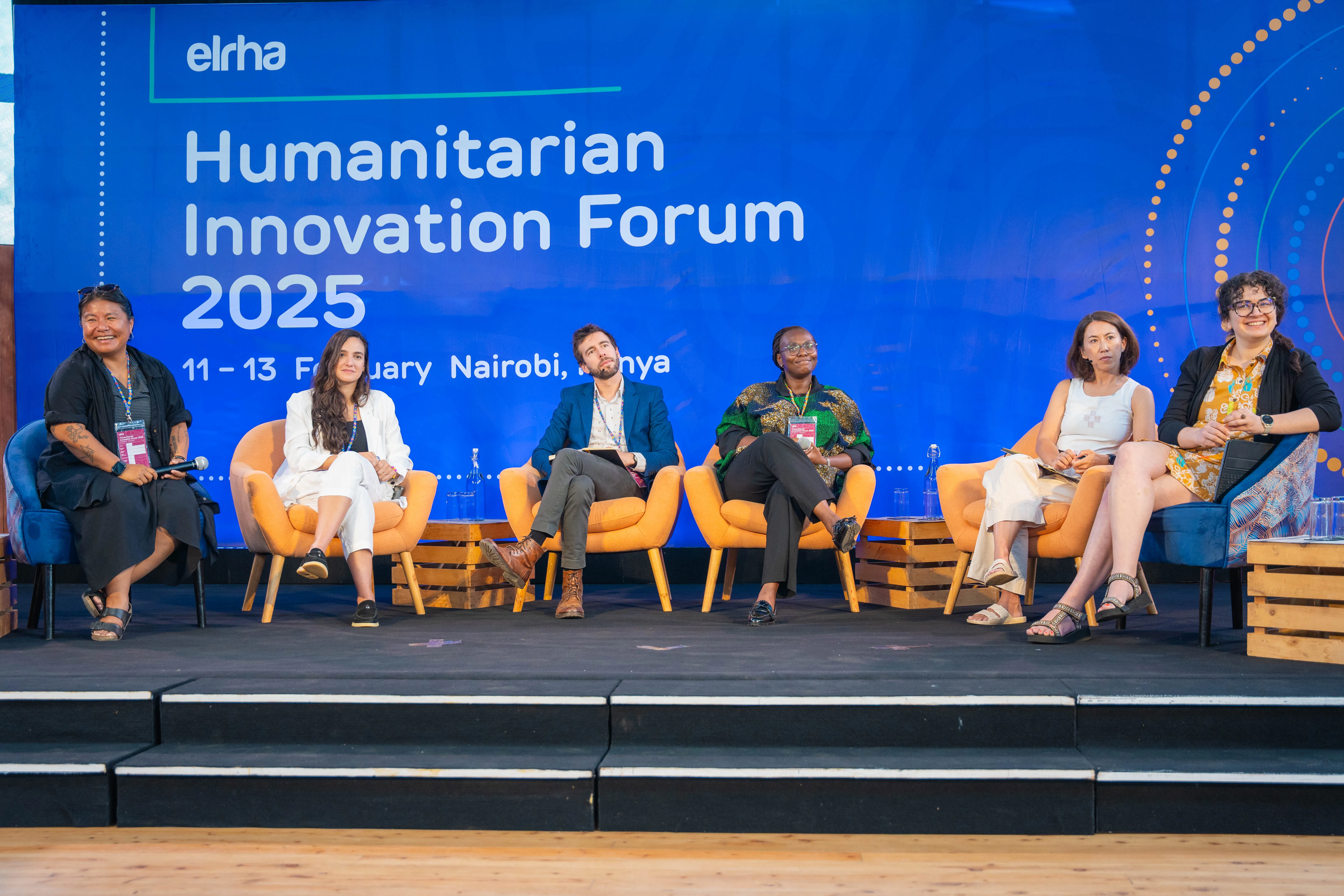 Photography from the Humanitarian Innovation forum 2025 in Nairobi, Kenya. In the image you can see six panellists engaging with the audience.