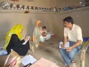 Benazir, R2HC Hygiene Promoter – Data Gatherer, conducts a session on personal hygiene for Abrab, 35, who has brought her son, Ajeeb, 12 months old, for follow-up at the CMAM site