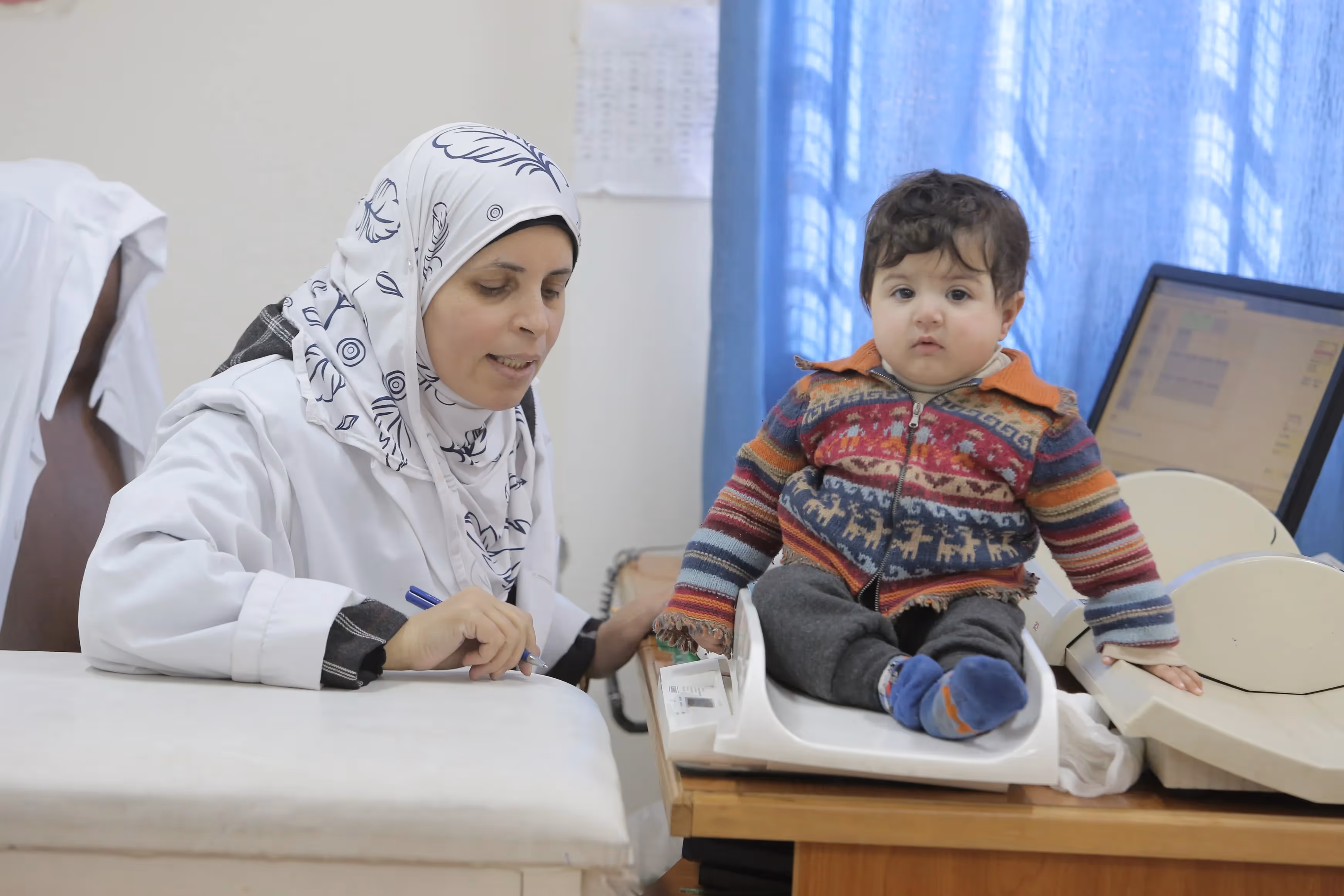 © UNRWA 2016 Photo by Mohammad Magayda A nurse measures Palestine refugee child weight at Irbid health Centre, Irbid, Jordan